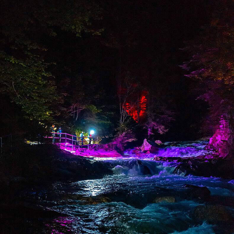 Die beleuchtete Groppensteinschlucht in der Nacht im Schein der Stirnlampe