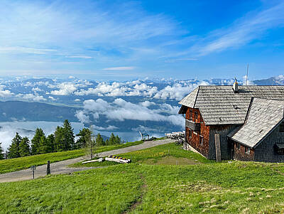 Die Alexanderhütte am Millstätter See ist von grünen Wiesen umgeben.