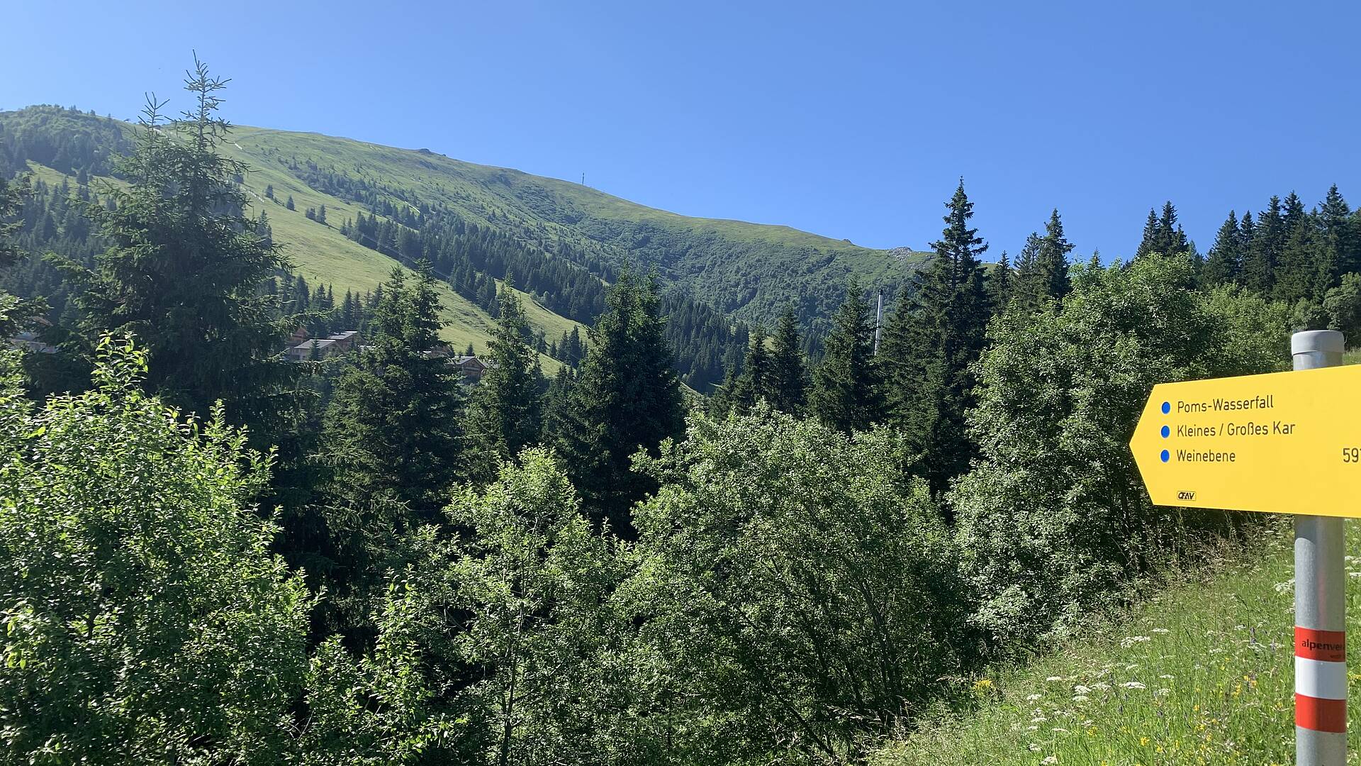 Wandern auf der Koralm. Abzweigung vom Parklplatz zum Poms Wasserfall und zur Großhöllerhütte